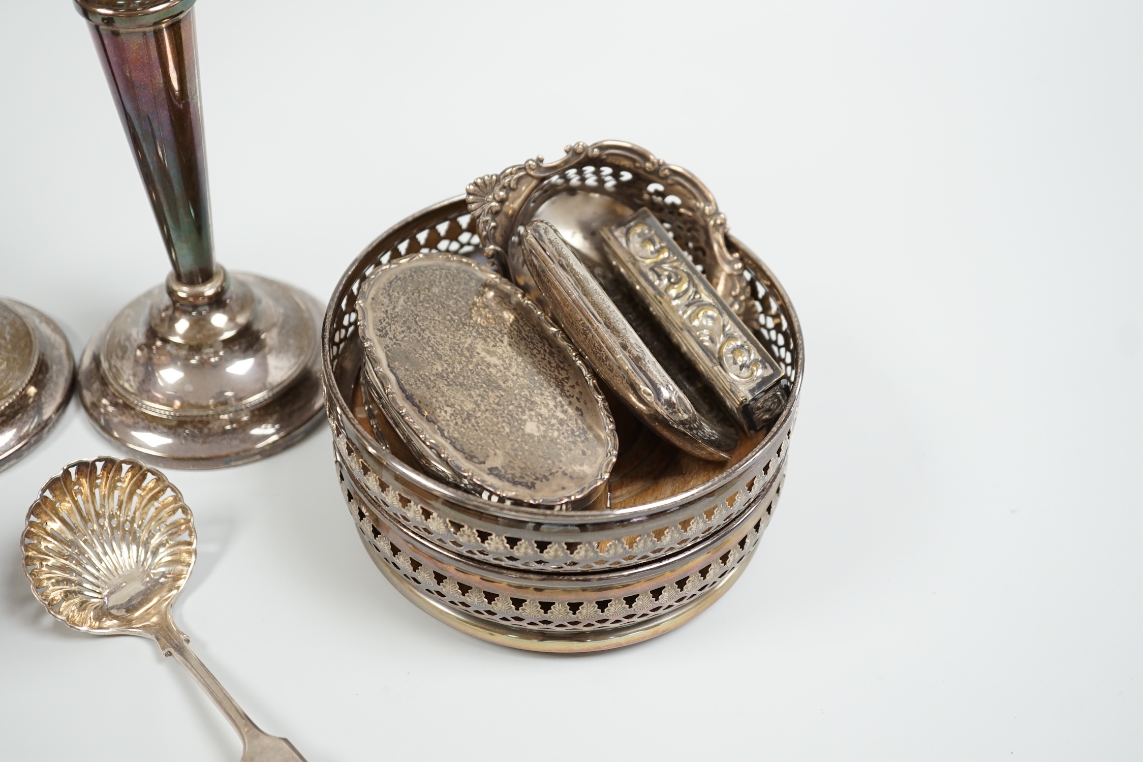 A pair of 1960's pierced silver wine coasters, London, 1968, diameter 13.2cm, a modern pair of silver candlesticks, a silver and tortoiseshell mounted glass salts bottle, a silver trinket box, sterling pierced dish, silv